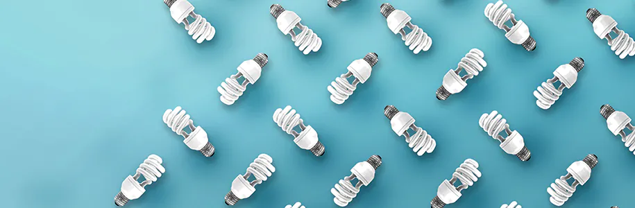 Energiesparlampe vor t&uuml;rkisem Hintergrund